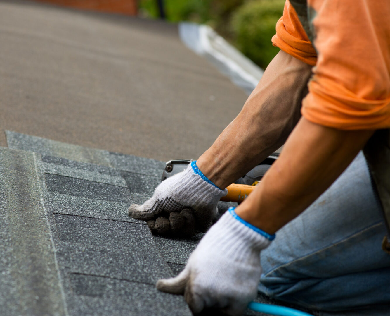 roofer Worker installing asphalt roof shingles.