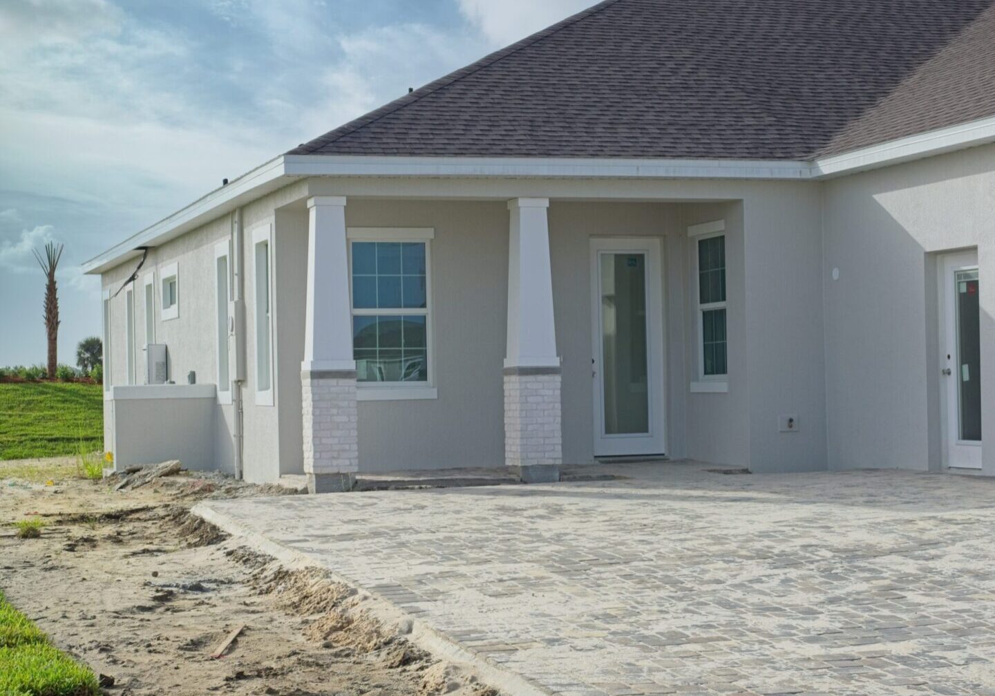 Details of Florida new home construction with driveway pavers Modern house exterior with paved patio area.