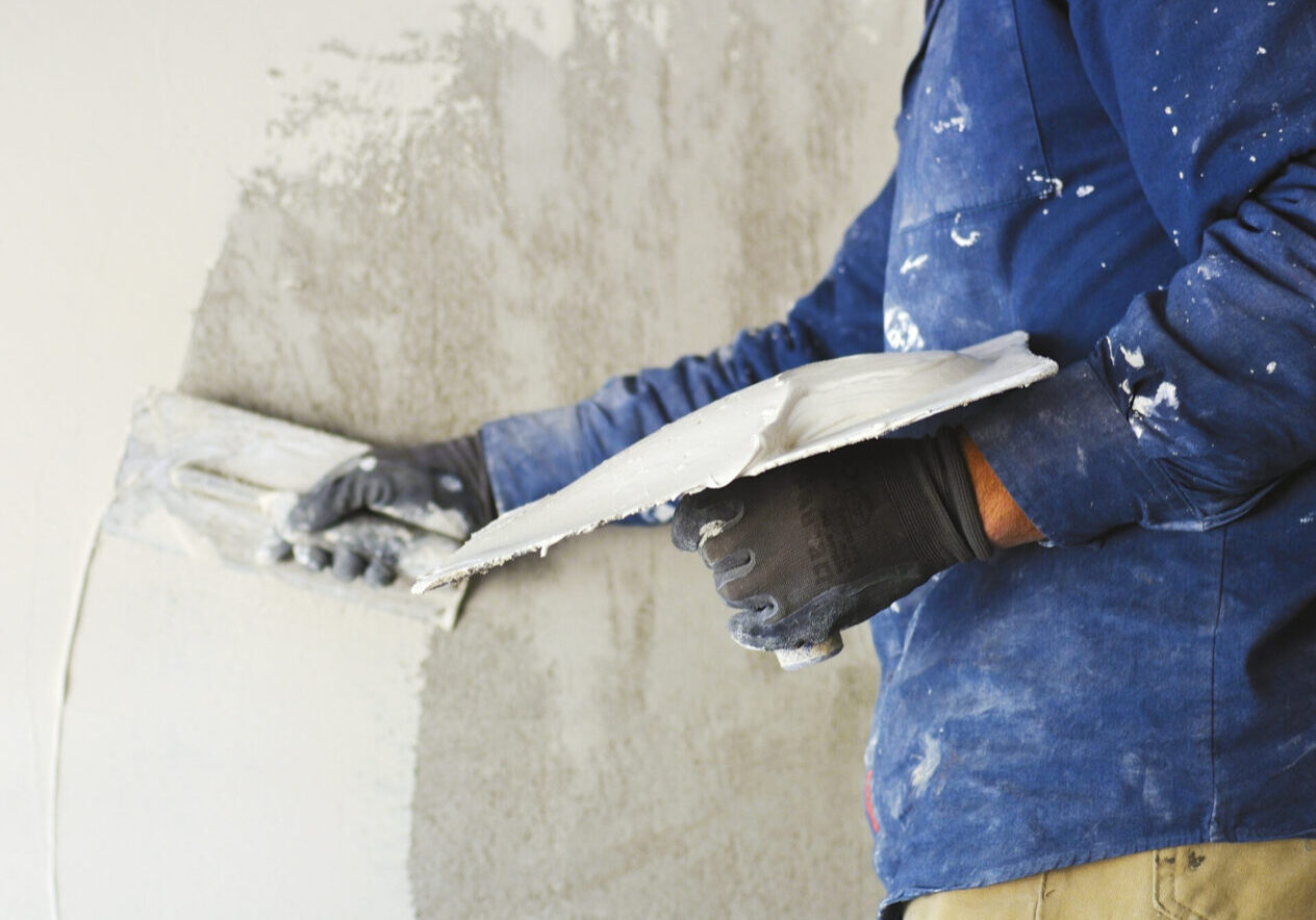 worker plastering tool plaster marble on interior plaster rough Person plastering a wall with trowel.